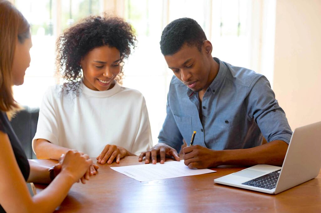 Two people signing a contract and receiving funding.