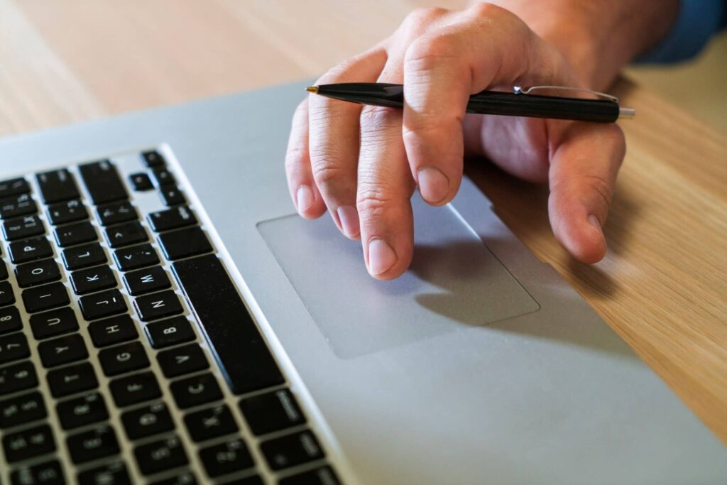 Close up of hand on laptop applying for a loan.